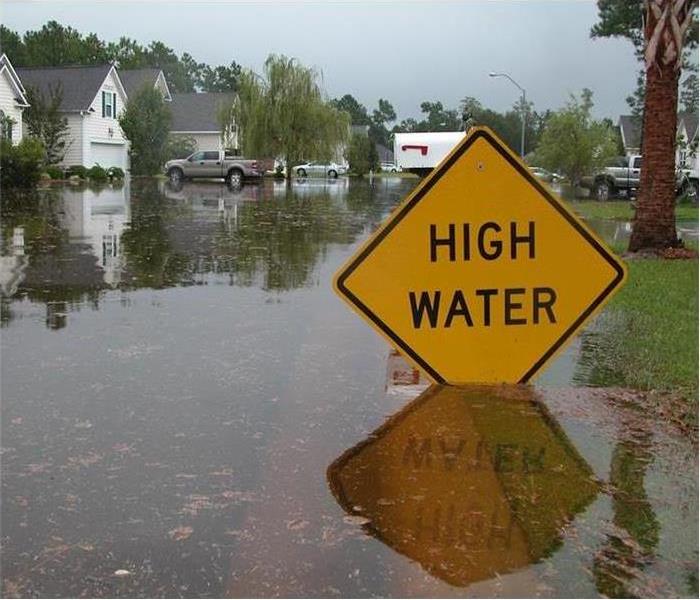 Flooded water around a yellow high water sign.